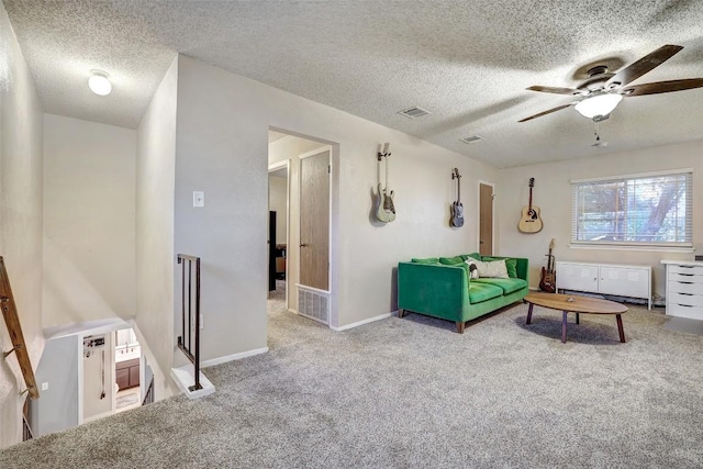 carpeted living room featuring baseboards, visible vents, ceiling fan, and a textured ceiling