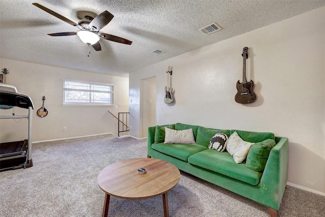 carpeted living room featuring visible vents, ceiling fan, a textured ceiling, and baseboards