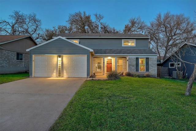 traditional home with brick siding, an attached garage, central AC unit, a front yard, and driveway