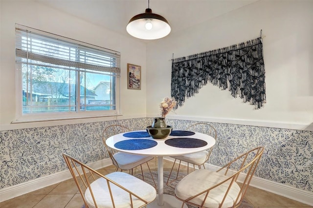 tiled dining room with baseboards, a wainscoted wall, and wallpapered walls