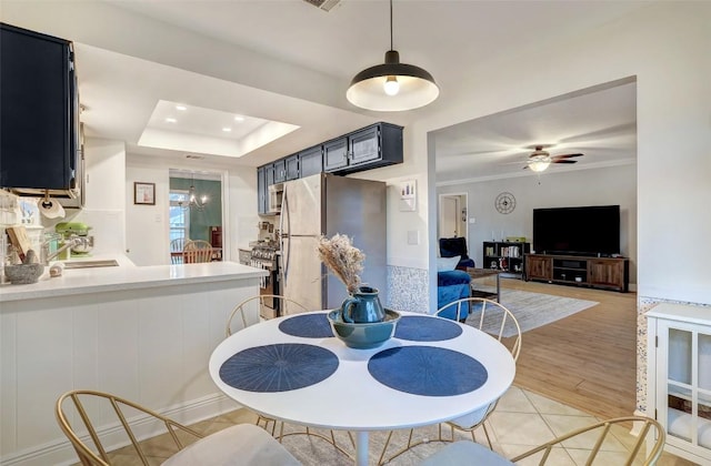 dining area with light tile patterned floors, a ceiling fan, ornamental molding, a tray ceiling, and recessed lighting