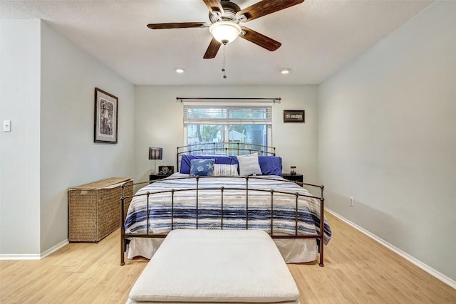 bedroom featuring baseboards, ceiling fan, and light wood-style floors