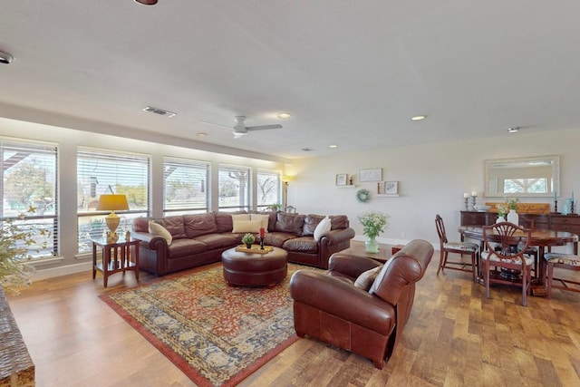 living area with light wood finished floors, visible vents, baseboards, recessed lighting, and a ceiling fan