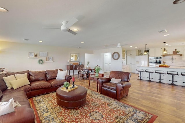 living area with recessed lighting, wood finished floors, visible vents, and ceiling fan