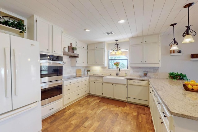 kitchen featuring visible vents, a sink, tasteful backsplash, white appliances, and wood ceiling