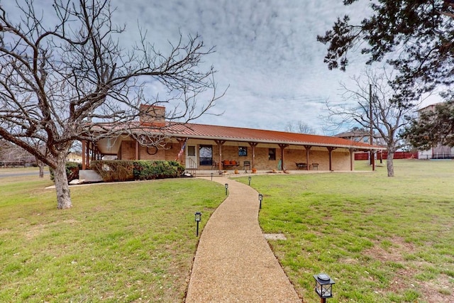 ranch-style house featuring a front lawn, brick siding, and a chimney