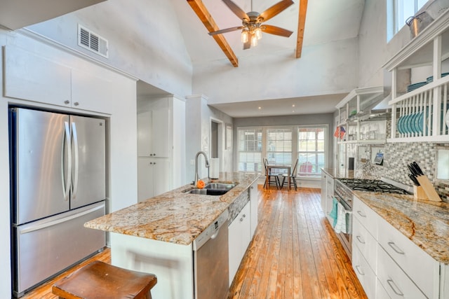 kitchen with a sink, visible vents, white cabinetry, appliances with stainless steel finishes, and light wood finished floors