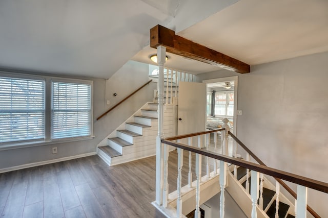 stairway with baseboards, wood finished floors, and beamed ceiling