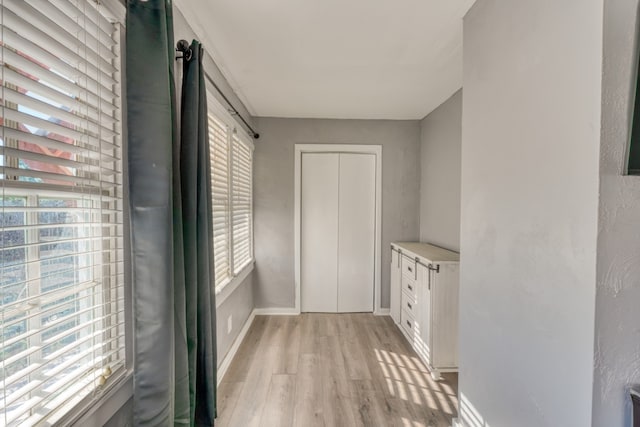 interior space with light wood-style floors and baseboards