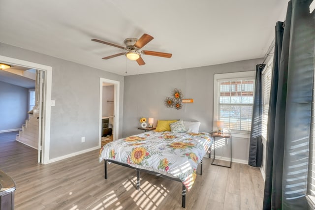 bedroom featuring ceiling fan, wood finished floors, and baseboards