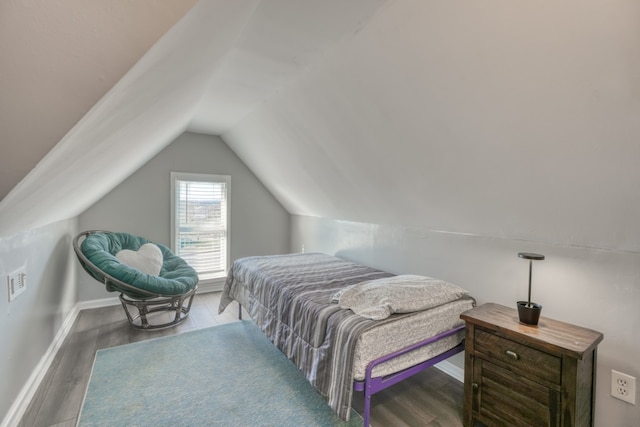 bedroom with baseboards, vaulted ceiling, and wood finished floors