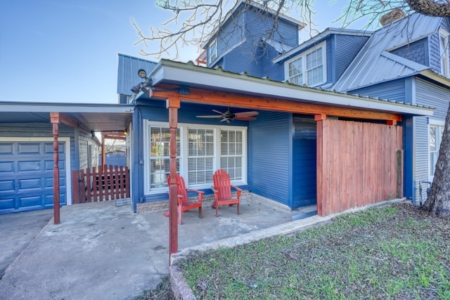 exterior space featuring a patio area, ceiling fan, and metal roof