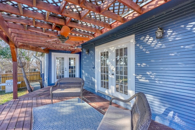 wooden terrace featuring ceiling fan, fence, a pergola, and french doors