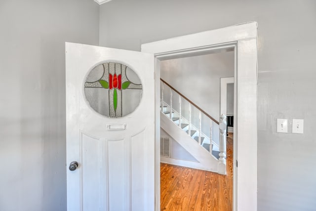 entryway featuring stairway, wood finished floors, and visible vents