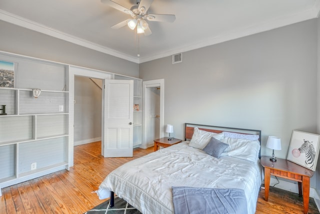 bedroom with visible vents, baseboards, a ceiling fan, ornamental molding, and wood finished floors