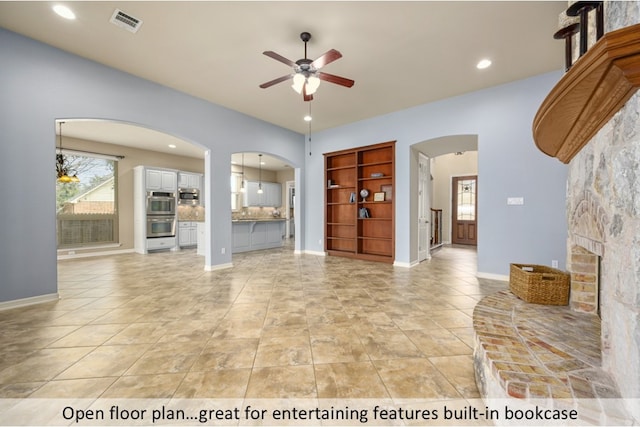 unfurnished living room featuring visible vents, arched walkways, baseboards, ceiling fan, and recessed lighting