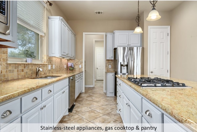 kitchen with visible vents, appliances with stainless steel finishes, decorative light fixtures, white cabinetry, and a sink