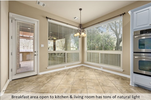 unfurnished dining area with visible vents, a notable chandelier, baseboards, and light tile patterned flooring