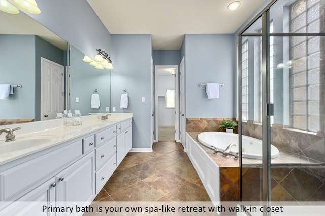 bathroom featuring double vanity, a garden tub, and a sink