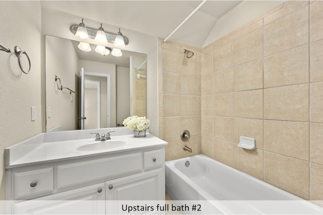 bathroom featuring vaulted ceiling, shower / bathing tub combination, and vanity