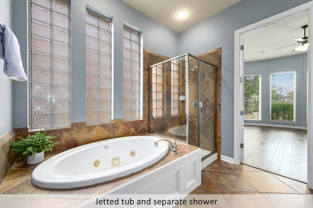 full bath featuring a tub with jets, a shower stall, a ceiling fan, and baseboards