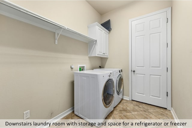 washroom with cabinet space, light tile patterned floors, baseboards, and washer and clothes dryer