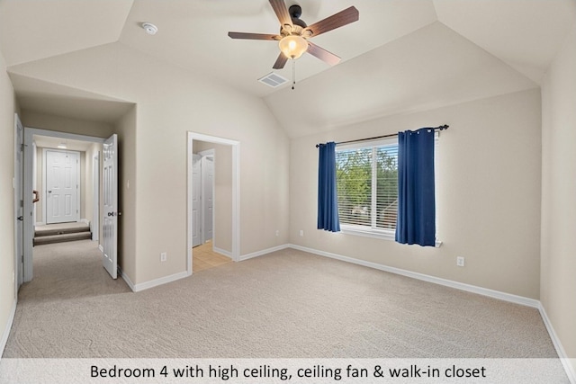 unfurnished bedroom with baseboards, visible vents, light colored carpet, and vaulted ceiling