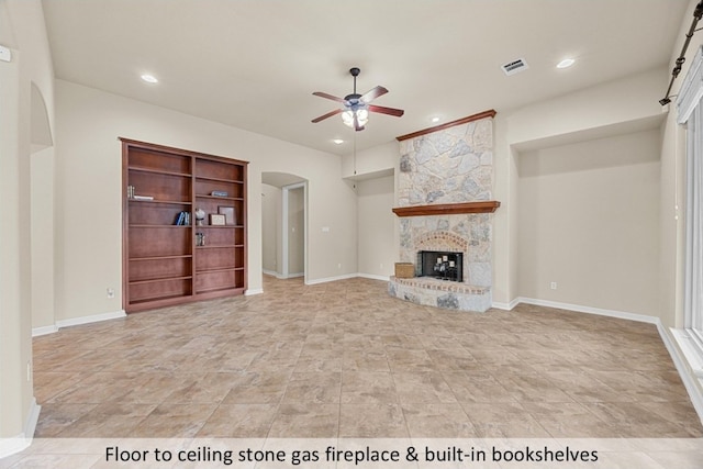 unfurnished living room featuring visible vents, ceiling fan, arched walkways, recessed lighting, and a stone fireplace