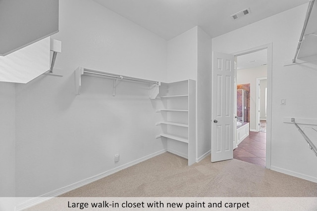 walk in closet with visible vents and carpet flooring
