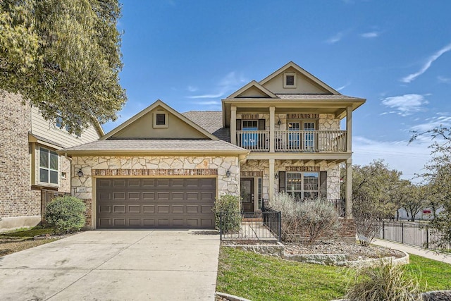 view of front facade with stone siding, concrete driveway, a balcony, and fence