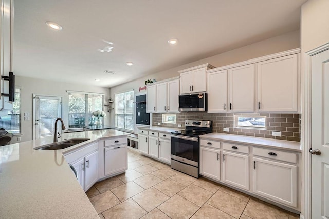 165 Crescent Heights Dr, Georgetown, TX 78628 - kitchen with stainless steel appliances, a sink, backsplash, light countertops, and recessed lighting