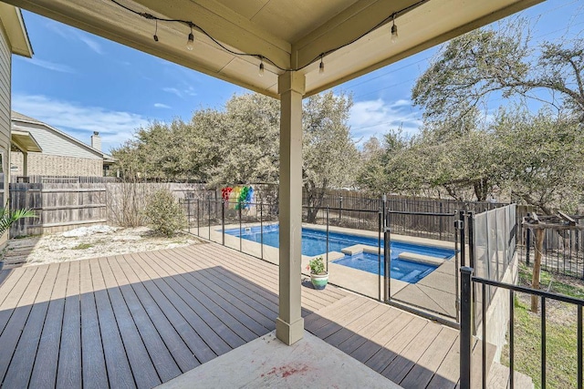 wooden terrace featuring a fenced in pool, an in ground hot tub, and a fenced backyard