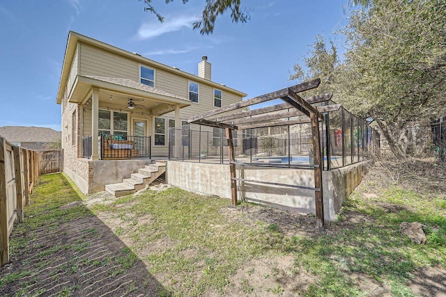 back of house featuring a fenced backyard, a pergola, ceiling fan, stairs, and a chimney