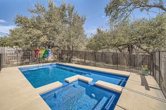 view of swimming pool with a pool with connected hot tub and a fenced backyard