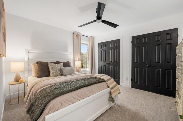 bedroom with carpet flooring, two closets, and a ceiling fan