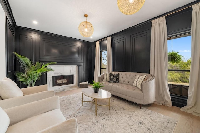 living area featuring light wood finished floors, a decorative wall, and a fireplace