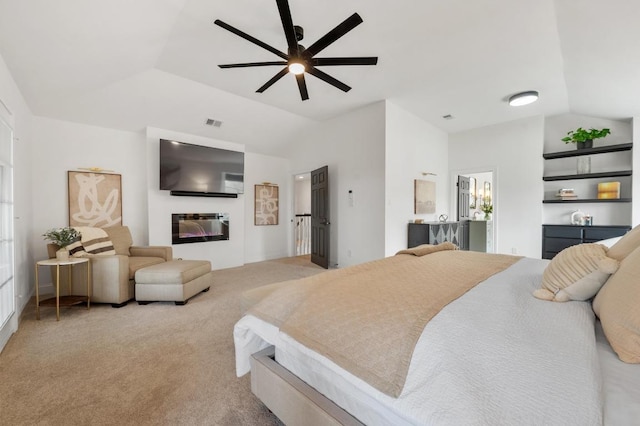 carpeted bedroom with a glass covered fireplace, lofted ceiling, a ceiling fan, and visible vents