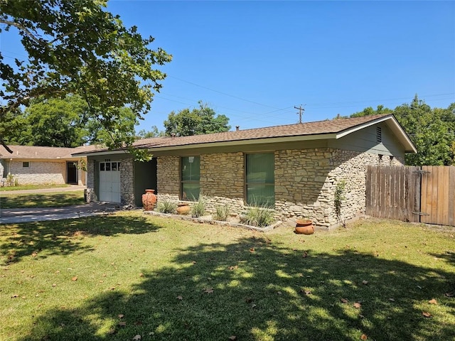 ranch-style house featuring driveway, a front lawn, an attached garage, and fence