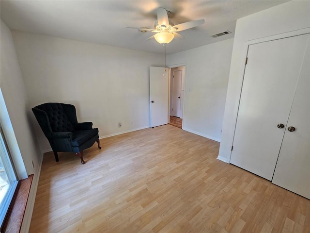 unfurnished room featuring light wood finished floors, baseboards, visible vents, and ceiling fan