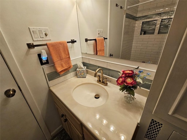 full bath with a tile shower and vanity