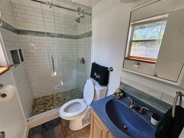 full bathroom featuring a shower stall, toilet, and vanity