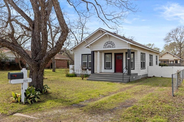 bungalow-style home with a porch, fence, and a front lawn