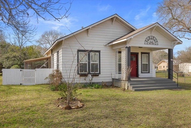 bungalow-style home featuring a porch, a front yard, and fence