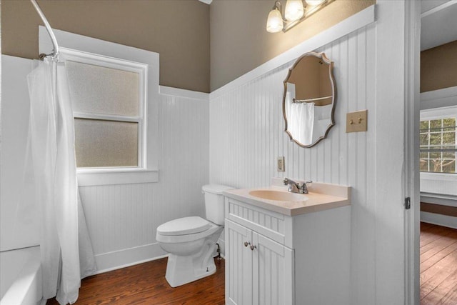 bathroom featuring toilet, baseboards, wood finished floors, and vanity