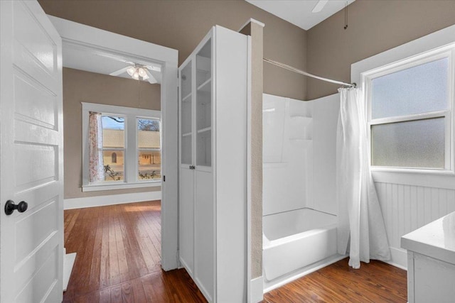 bathroom featuring shower / tub combo, hardwood / wood-style floors, a ceiling fan, and vanity