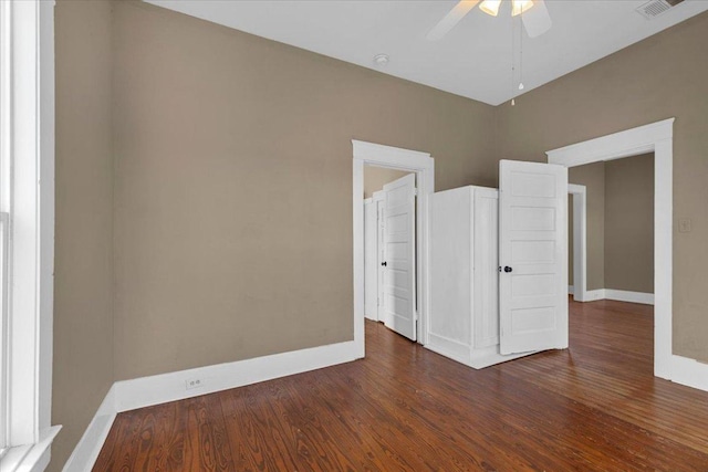 empty room with a ceiling fan, visible vents, baseboards, and wood finished floors