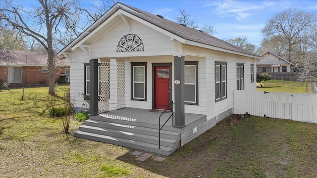 view of front of house featuring a porch, fence, and a front lawn