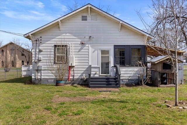 back of house with entry steps, crawl space, fence, and a lawn