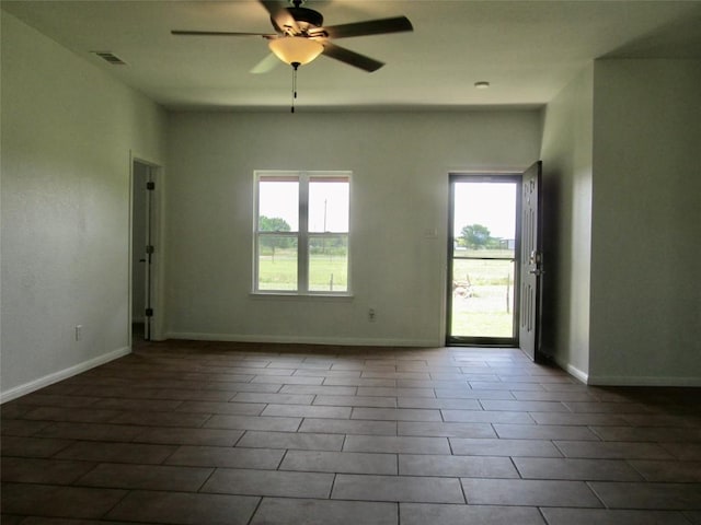 spare room with visible vents, a ceiling fan, and baseboards