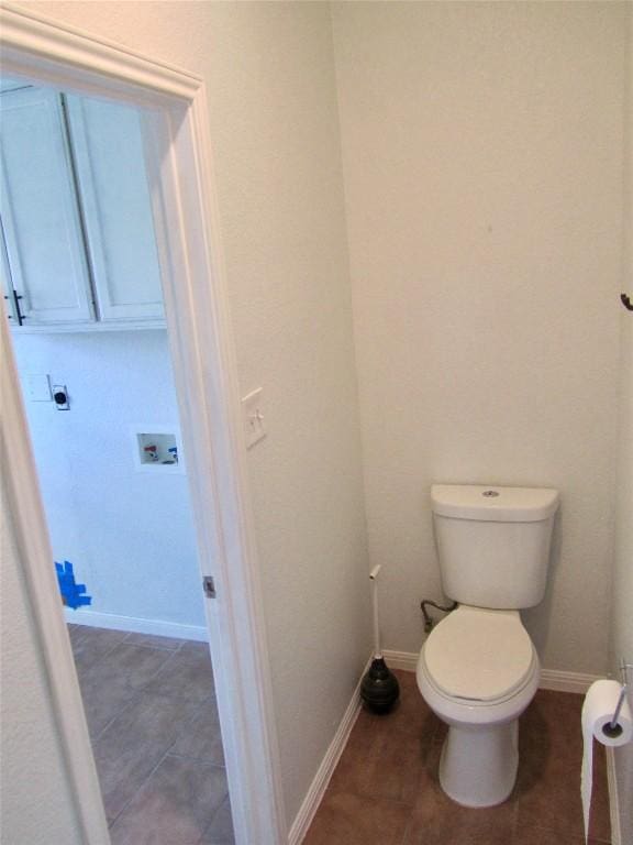 bathroom featuring tile patterned flooring, toilet, and baseboards